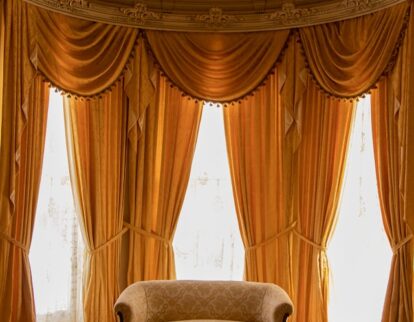 fancy orange curtains next to sofa